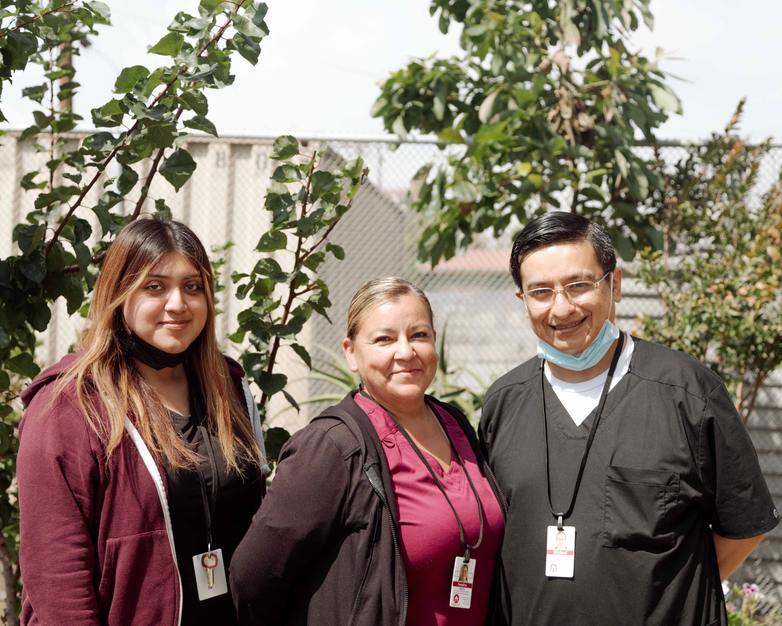 three drop in staff members standing